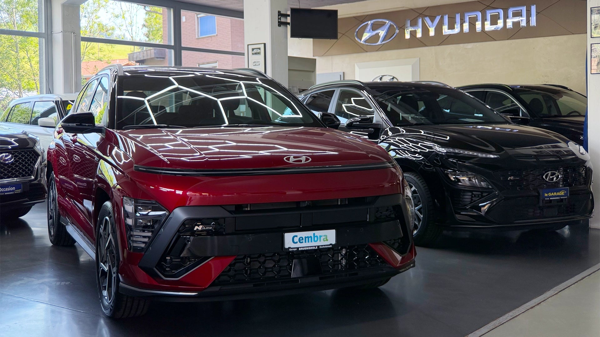 Moderner Hyundai Showroom der Touring Garage Brünisholz in Escholzmatt mit einem roten Hyundai KONA N-Line und weiteren Modellen.